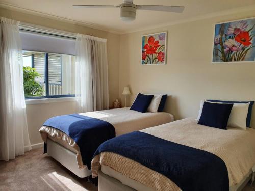 a bedroom with two beds and a window at Abalone Guest Accommodation in Lakes Entrance