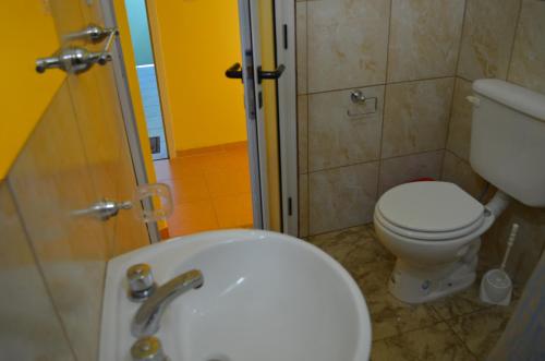 uma casa de banho com um WC branco e um lavatório. em Suyana Departamentos em Tinogasta