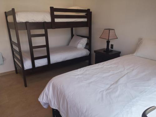 a bedroom with two bunk beds and a lamp at Pinares de Higuerillas in Maitencillo