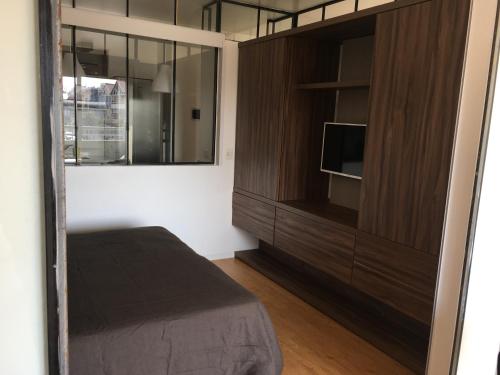 a bedroom with a bed and a large wooden cabinet at Puravida DOHO cerca de todo in Buenos Aires