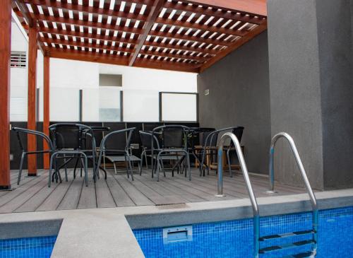a patio with a table and chairs next to a swimming pool at Departamento 100 m2 con luz natural Seguridad 24h in Lima