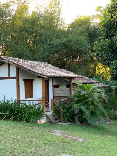 a small white house with a thatched roof at Pousada Jakuara in Arraial d'Ajuda