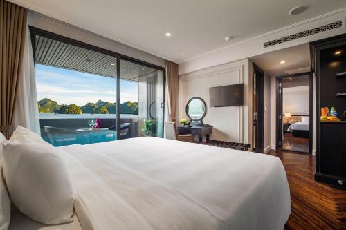 a bedroom with a large white bed and a large window at Stellar of the Seas Cruise in Ha Long