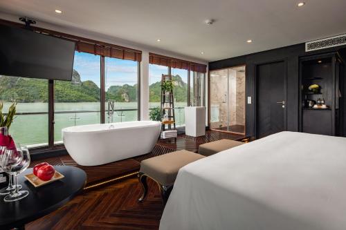 a bedroom with a large bed and a bath tub at Stellar of the Seas Cruise in Ha Long