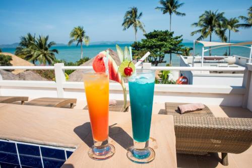 duas bebidas numa mesa com vista para o mar em Serenity Resort Koh Chang em Ko Chang