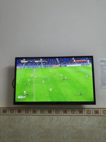 a flat screen tv on a wall with a soccer game at Khách Sạn Thiên Phong in Buon Ma Thuot