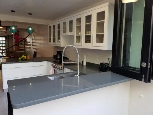 a kitchen with a sink and white cabinets at Nanny Estates Cabarete kiters Condo C-6 in Cabarete