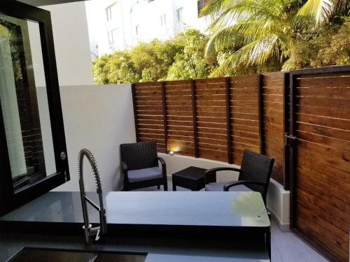 a balcony with chairs and a bed and a fence at Nanny Estates Cabarete kiters Condo C-6 in Cabarete
