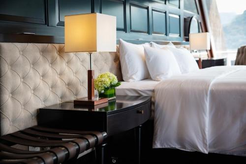 a hotel room with two beds and a table with a lamp at Stellar of the Seas Cruise in Ha Long