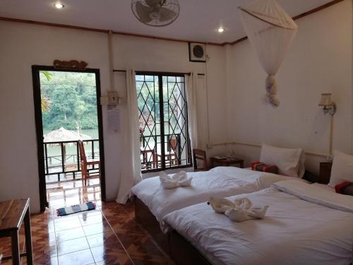 ein Schlafzimmer mit 2 Betten und Handtüchern darauf in der Unterkunft Nam Ou River Lodge in Nongkhiaw