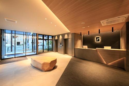 a lobby with a bench in the middle of a room at S-peria Inn Nihombashi Hakozaki in Tokyo