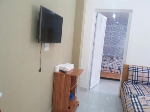 a room with a tv on the wall and a bed at MrLee Dalat House in Da Lat