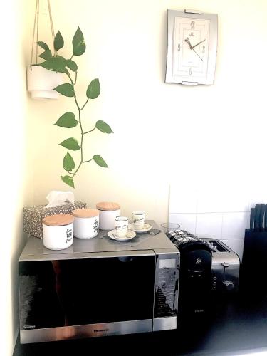 a microwave sitting on top of a table with dishes on it at Namely Manly in Sydney