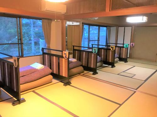 a room with three bunk beds on the floor at K's House Hostels - Hakone Yumoto Onsen in Hakone