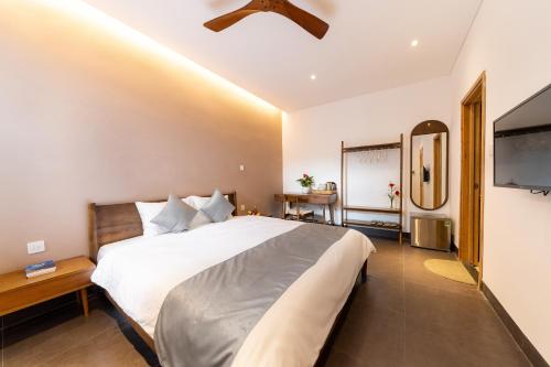 a bedroom with a large bed with a ceiling fan at Phuoc Linh Homestay in An Bang
