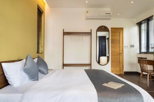 a bedroom with a large white bed and a mirror at Phuoc Linh Homestay in An Bang