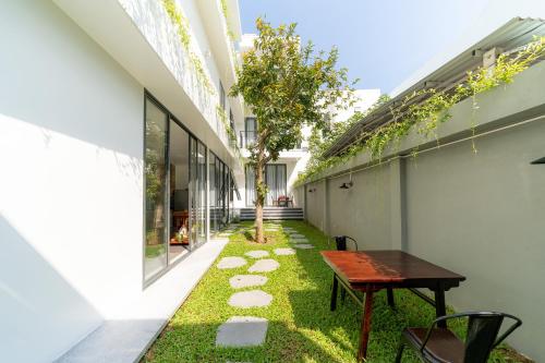 an internal courtyard of a building with a table and grass at Phuoc Linh Homestay in An Bang