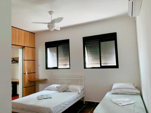 Giường trong phòng chung tại BEACH HOUSE Unidade 1 Casa de Praia Guarujá - 180 Metros do Mar