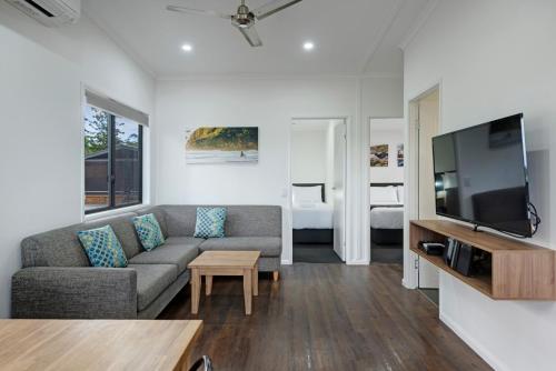 a living room with a couch and a flat screen tv at Discovery Parks - Forster in Tuncurry