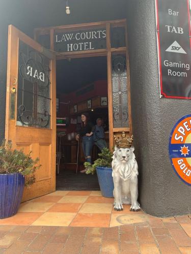 a woman standing in front of a store with a dog at Law Courts Hotel in Dunedin