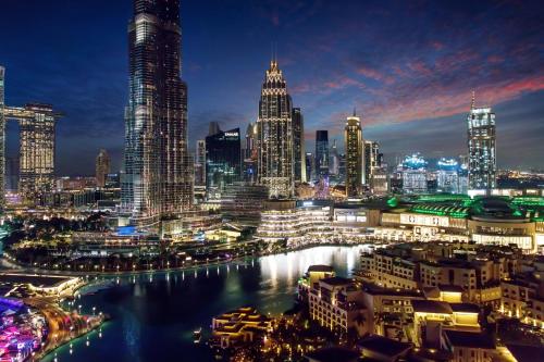 uma vista para o horizonte da cidade à noite em FAM Living - The Residences Tower - Burj Khalifa & Fountain Views em Dubai