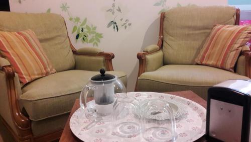 a living room with two chairs and a table with a tea kettle at La chambre Tomis Ath in Ath