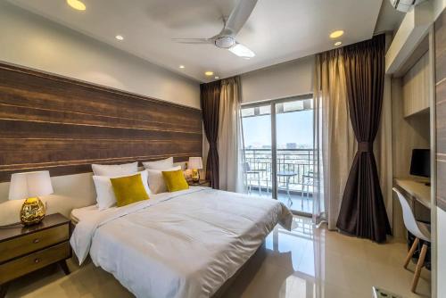 ein Schlafzimmer mit großem Bett und Balkon in der Unterkunft Families & Corporates 3-Bed Apt, Fashion Res, Pune in Pune