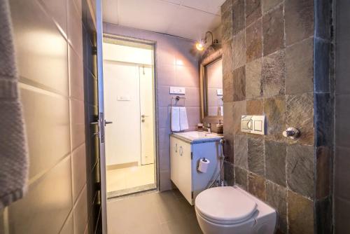 ein kleines Badezimmer mit Toilette und Waschbecken in der Unterkunft Families & Corporates 3-Bed Apt, Fashion Res, Pune in Pune