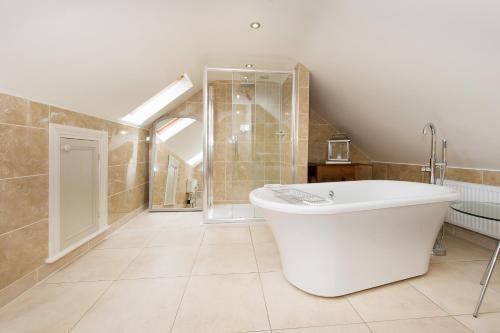 a large bathroom with a tub and a shower at Drake Cottage in Whitby