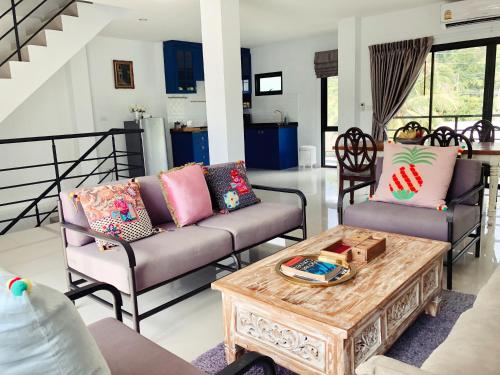 a living room with two couches and a coffee table at Villa Think Of Home in Khao Lak