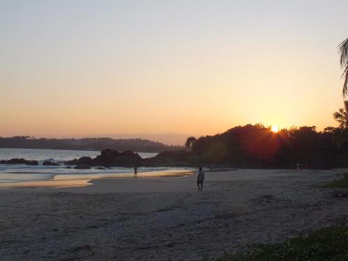 a person walking on the beach at sunset at Abraham Beach House in Tangalle