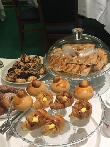 a table with two plates of pastries and other desserts at Panorama Hotel in Siracusa
