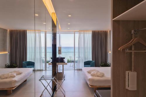 a hotel room with two beds and a view of the ocean at Posia Retreat & Spa UNA Esperienze in San Foca