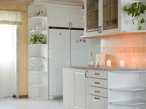 a kitchen with white cabinets and a white refrigerator at Stegemans Horse hotel and Country Lodge in Ljungby