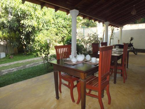 a wooden table and chairs on a patio at Abraham Beach House in Tangalle