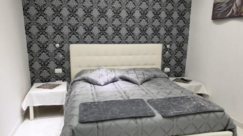 那不勒斯luxury room al cristo velato的一间卧室，配有一张大床和两张桌子