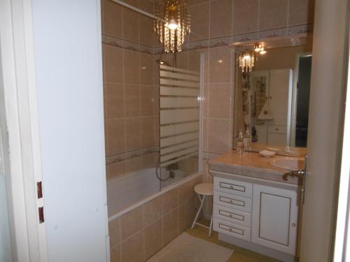 a bathroom with a tub and a sink and a shower at Résidence Costallat in Bagnères-de-Bigorre