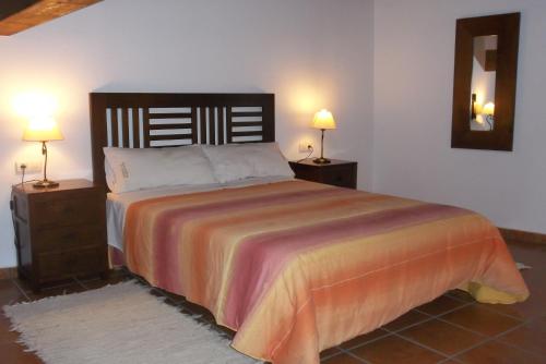 Casa Rural El Temple في Las Cuevas de Cañart: غرفة نوم بسرير كبير مع مواقف ليلتين