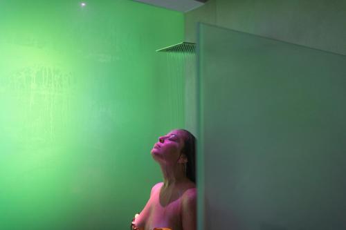 a woman standing in front of a green wall at Posia Retreat & Spa UNA Esperienze in San Foca
