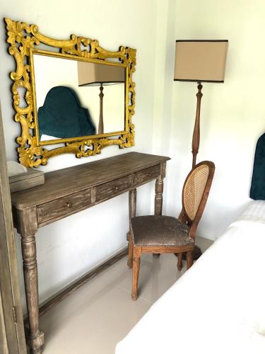 a dressing table with a mirror and a chair at Villa Think Of Home in Khao Lak