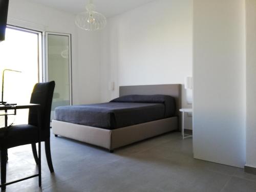 a bedroom with a bed and a table and a chair at Chiaralice in Noto