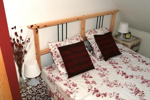 a bed with a wooden frame with flowers on it at Siedliskogaj in Wojciechów