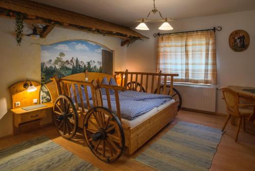 1 dormitorio con cama de madera con ruedas torcidas en Familienhotel Hochrieß en Purgstall