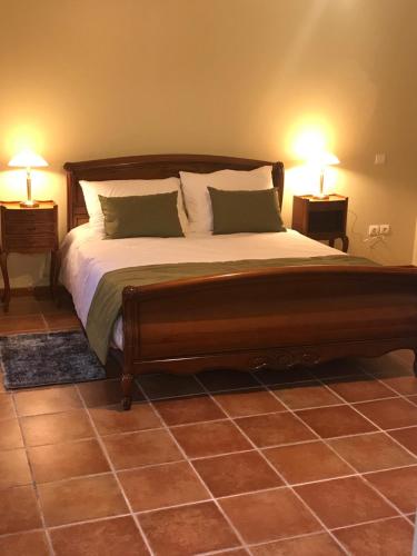 a bedroom with a large wooden bed with two lamps at Gite Le Rucher in Rumegies