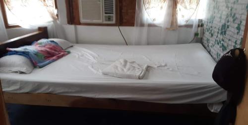 a bed with white sheets and towels on it at SHUKRAN Apartelle in Siquijor