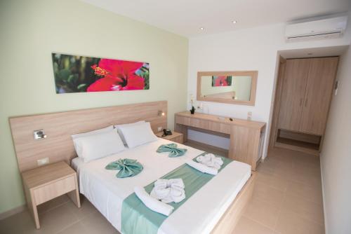 a bedroom with a white bed with towels on it at Meliton Hotel in Theologos