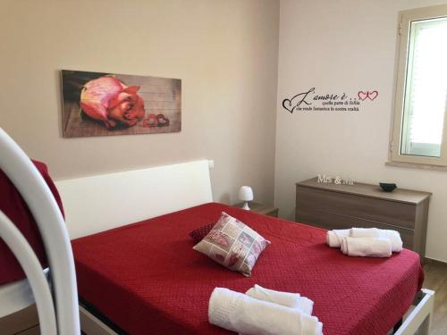 a bedroom with a red bed with two towels on it at Horizon home in Torre Lapillo