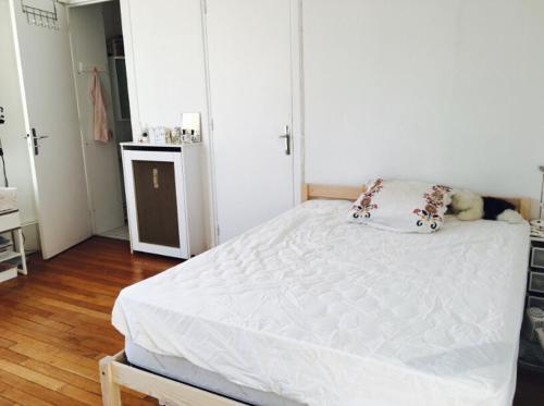 - une chambre dotée d'un lit blanc avec un ours en peluche dans l'établissement Best located flat in Saint-Germain-des-Prés, à Paris