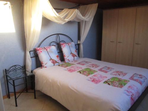 a bedroom with a bed with white sheets and pink pillows at Vakantiewoning Upstairzzz in Kortessem