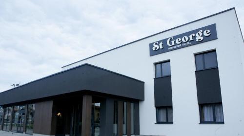 a white building with a sign on the top of it at Boutique Hotel St Georgije in Banja Luka